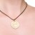Celtic knot necklace made in natural PU coated brass. Circle shaped. On leather strap.